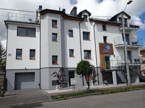 a white building on the side of a street at La Mer Pokoje i Apartamenty in Władysławowo