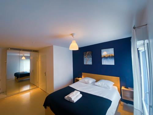 - une chambre bleue avec un lit et 2 serviettes dans l'établissement Le Monseigneur's House - Duplex hyper centre, à Courcouronnes