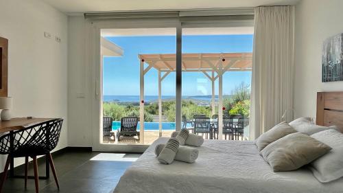 a bedroom with a bed and a view of a pool at Villas Tin Coves Noves in Punta Grossa