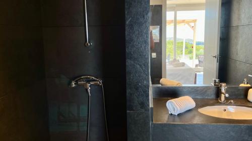 a bathroom with a sink and a mirror at Villas Tin Coves Noves in Punta Grossa