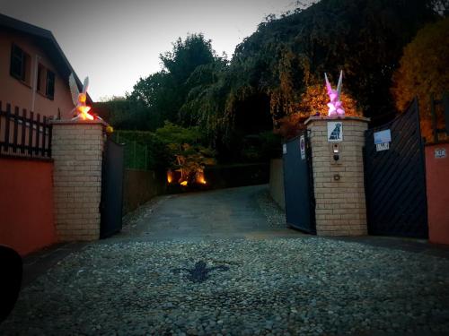 a driveway with two gates with fire torches on them at B&B Margot in Albavilla
