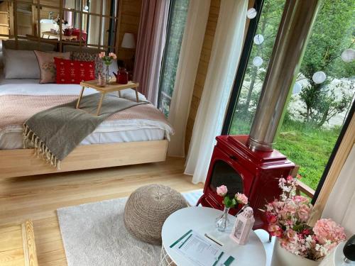 a bedroom with a bed and a red wood stove at Vagona Tiny House in Rize