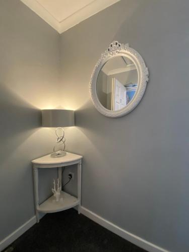 a white room with a mirror and a table at Barriemore Oban in Oban