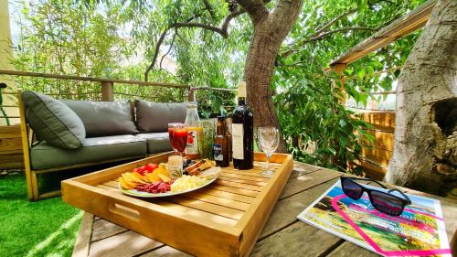 - une table avec une assiette de fruits et des bouteilles de vin dans l'établissement Le Micocoulier, à Montesquieu
