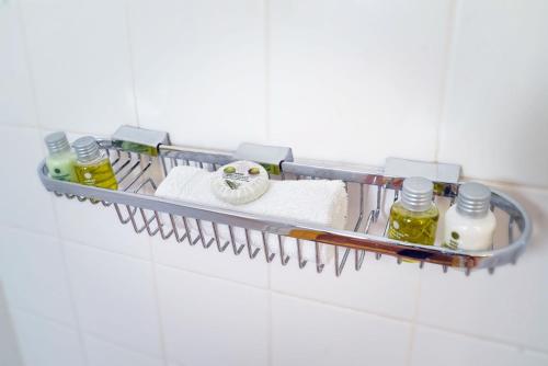 a bathroom rack with towels and oils on a wall at The Tony Hotel South Beach in Miami Beach