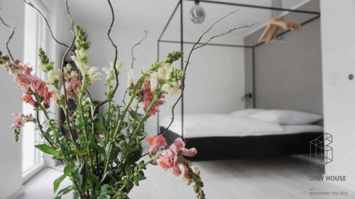 een slaapkamer met een bed en een vaas met bloemen bij The Grey House in Kröv