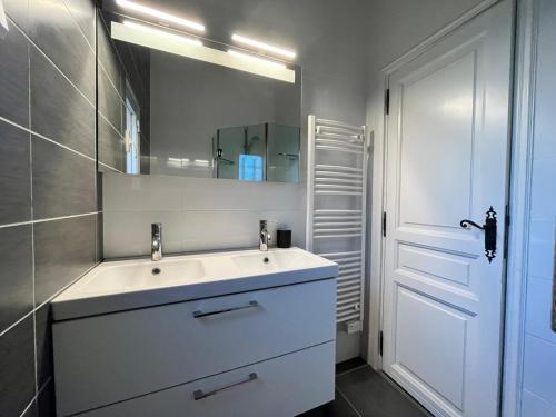 une salle de bain avec un lavabo blanc et un miroir dans l'établissement Les Hauts de Bonporteau - nr 29, à Cavalaire-sur-Mer