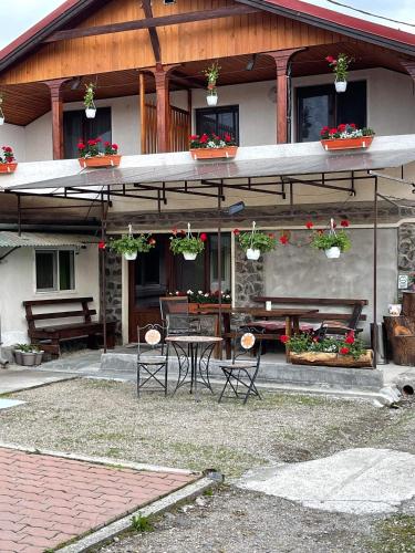 a house with a table and chairs in front of it at Gyongyver Panzio in Sfântu-Gheorghe