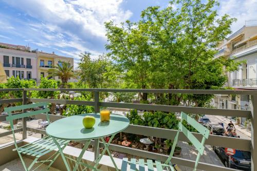 un balcón con mesa, sillas y un árbol en Aura Homes, Contemporary Apartments in Central Athens en Athens