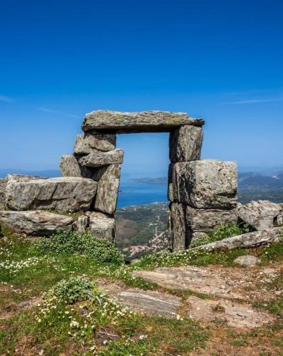 a stone window on top of a hill with the ocean at Venus Beach Hotel in Nea Stira
