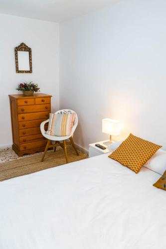 a bedroom with a bed and a chair and a dresser at House Los Angeles in Chulilla
