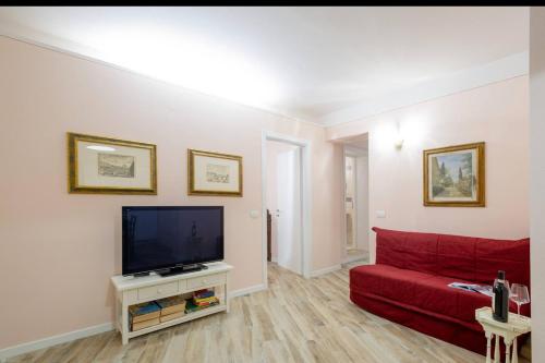 a living room with a red couch and a flat screen tv at Residenza dei Piaceri Perduti-Rosa in Lastra a Signa
