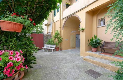 a courtyard with flowers and a bench and a building at Residenza dei Piaceri Perduti-Rosa in Lastra a Signa