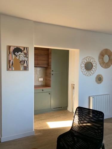un salon avec une chaise et une cuisine dans l'établissement Superbe appartement avec parking gratuit sur place, à Soorts-Hossegor