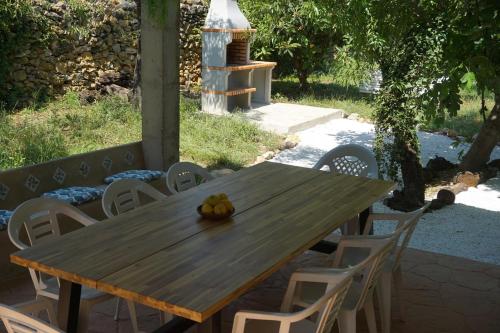 - une table et des chaises en bois avec un bol de fruits dans l'établissement Casa El Regall, à Cálig