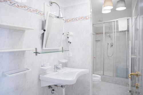 a white bathroom with a sink and a shower at TIMO - Villa Luisa: con vasca idromassaggio privata in Casarza Ligure
