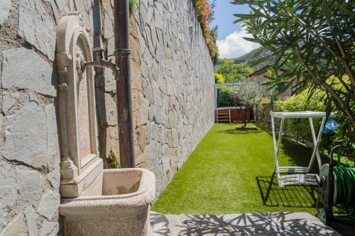 a stone building with a yard with green grass at TIMO - Villa Luisa: con vasca idromassaggio privata in Casarza Ligure