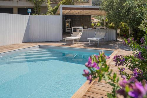 a swimming pool with two chairs and a table at TIMO - Villa Luisa: con vasca idromassaggio privata in Casarza Ligure