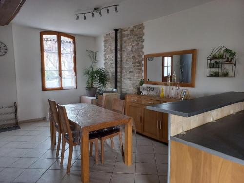 a kitchen with a wooden table and a dining room at maison chaleureuse solognote mitoyenne in La Ferté-Saint-Aubin