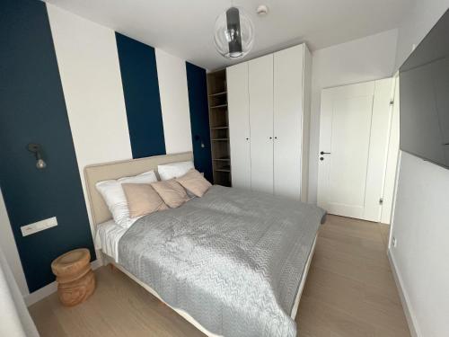 - une chambre avec un lit aux murs bleus et blancs dans l'établissement Apartament Polanki Aqua A408, à Kołobrzeg