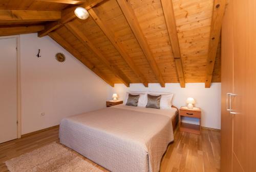 a bedroom with a bed and wooden ceilings at Marina Holiday home in Postira