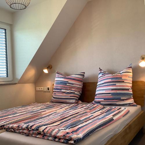 a bed with two pillows on it in a room at Zeitlos Bodensee in Friedrichshafen