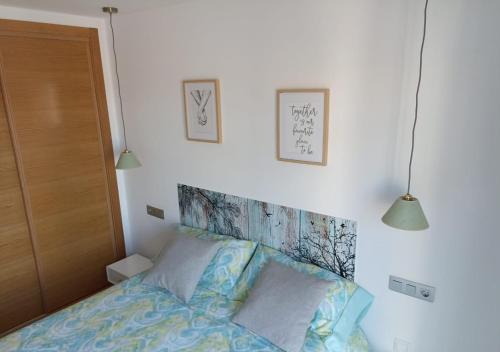 ein Schlafzimmer mit einem Bett mit zwei Leuchten darüber in der Unterkunft Fabuloso Atico En Terrazas De La Torre in Roldán