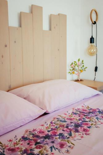 a bed with a pink bedspread with flowers on it at Βίλλα Φανούλα Villa Fanoula in Chorto