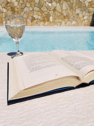 an open book on a table with a glass of wine at City Apartment One in Mostar