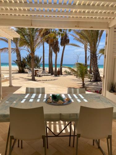 a table and chairs on the beach with the ocean at Villa Nº 25 Alfredo Marchetti Suites on the Beach,Praia de Chaves BV in Cabeçadas