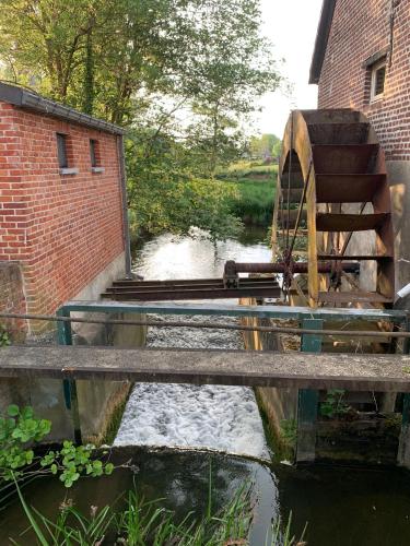 a bridge over a river with a water mill at B&B elzartwinning in Hasselt