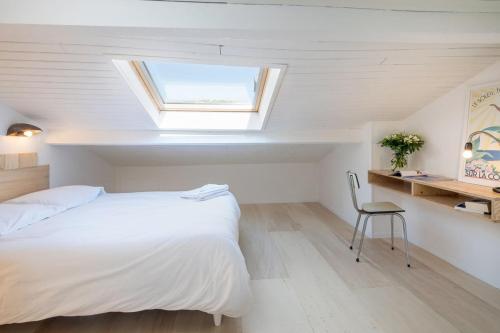 a bedroom with a white bed and a skylight at La Mansarde du Port HOME STAY in Nice