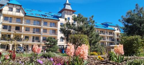 a building with flowers in front of it at BLUE MARE Apartamenty MES in Łukęcin