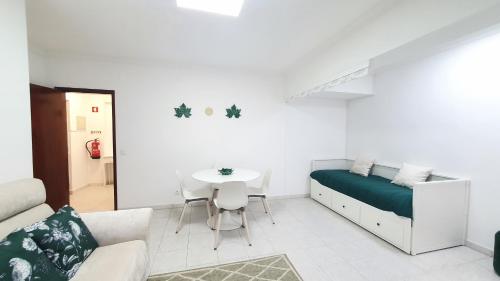 a white room with a bed and a table at Caldas da Rainha's Green & White in Caldas da Rainha