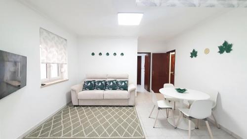 a living room with a couch and a table at Caldas da Rainha's Green & White in Caldas da Rainha