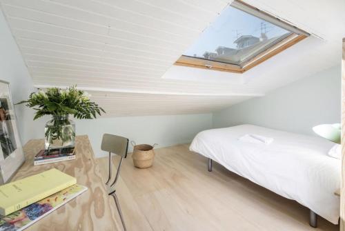 a bedroom with a bed and a window on the ceiling at La Mansarde du Port HOME STAY in Nice