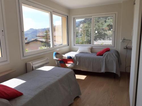 a bedroom with two beds and two windows at Chic Coastal Hill Escape in Ventimiglia