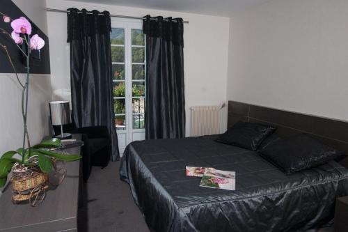 a bedroom with a bed and a window at Logis Hotel Restaurant Le Bellevue in Prats-de-Mollo-la-Preste