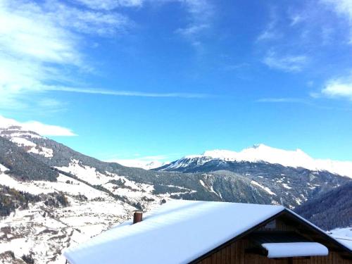 a snow covered roof of a building with mountains in the background at Modern Apartment in Hochgallmigg with Balcony in Hochgallmig