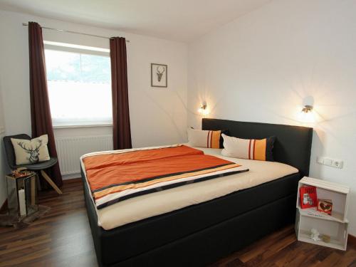 a bedroom with a bed with an orange blanket on it at Modern Apartment in Hochgallmigg with Balcony in Hochgallmig