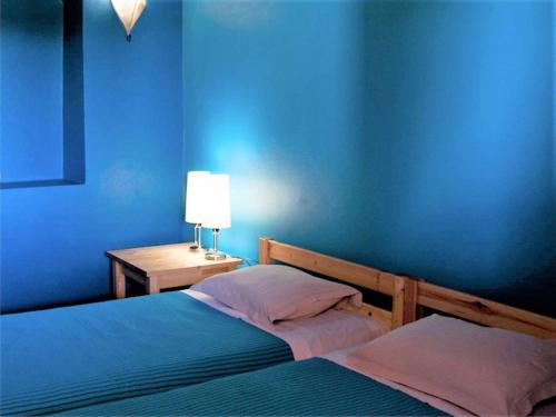 une chambre bleue avec deux lits et une table avec une lampe dans l'établissement Holiday Home in Guadiana Park near River, à Mértola