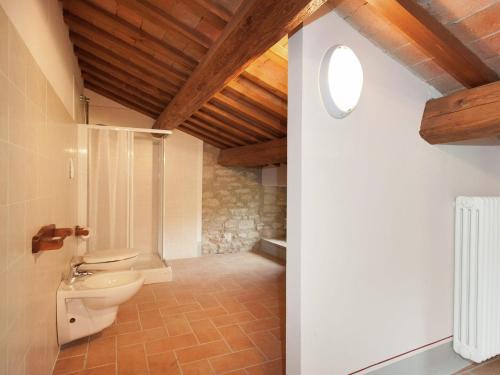 baño con aseo y techo de madera. en Appealing apartment in Modigliana with garden, en Tredozio