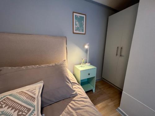 a small bedroom with a bed and a night stand at Hotel Florencia in Viña del Mar