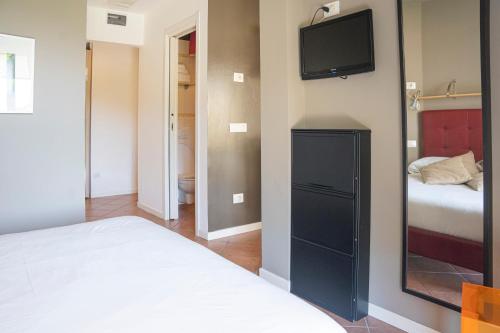 a bedroom with a bed and a tv on a wall at ALOE - Villa Luisa: Pace e Relax a 2 passi dal mare in Casarza Ligure