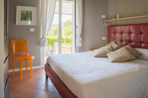 ein Schlafzimmer mit einem Bett, einem Stuhl und einem Fenster in der Unterkunft ALOE - Villa Luisa: Pace e Relax a 2 passi dal mare in Casarza Ligure