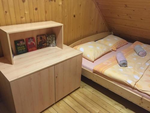 2 camas en una habitación de madera con libros en Velika planina Chalet SLOVENKA en Stahovica