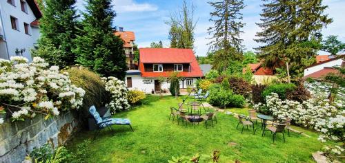 um quintal com cadeiras e mesas e uma casa em Domek Artysty em Szklarska Poręba