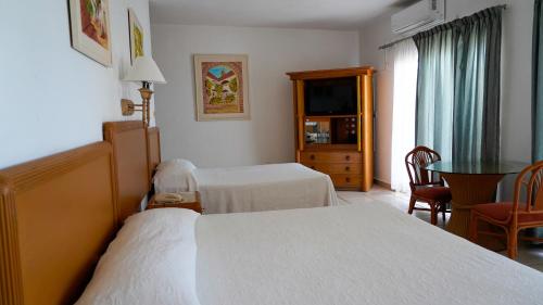 a hotel room with a bed and a television at Tropicana Hotel Puerto Vallarta in Puerto Vallarta