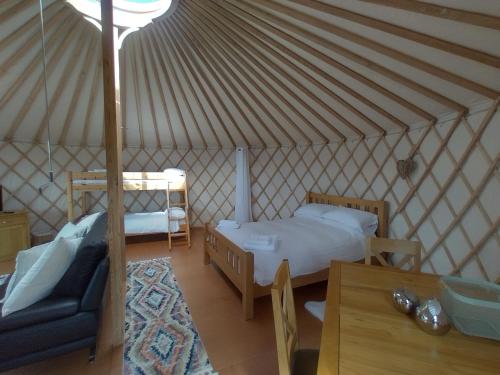 a room with a bed and a couch in a yurt at Embrace the Space in Cwm-Morgan
