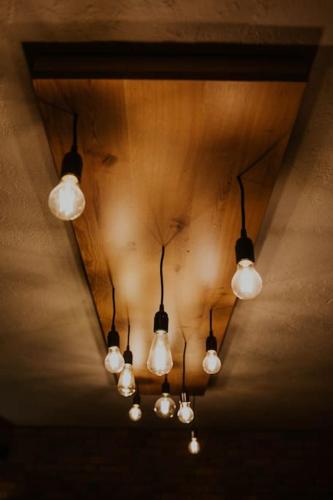a row of lights hanging from a ceiling at Haloze na dlani - Haloze in your hand, hiša s pogledom na hribe - a house vith a view of hills in Gruškovec
